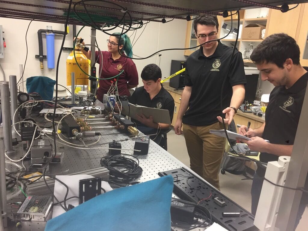 Undergraduate students testing equipment in a lab.