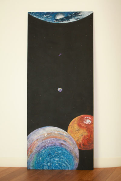"Falling" is composed of pastel on a black sheet of wood. It is 6ft tall and 2ft wide. Most of the painting is black with a few scattered stars. Immense planets are found at the ends of the scene. A small purple and gold craft falls away from Earth at the top of the painting and down toward an equally miniscule target: 16-Psyche. This asteroid sits at the center of the painting, floating between Jupiter and Mars.