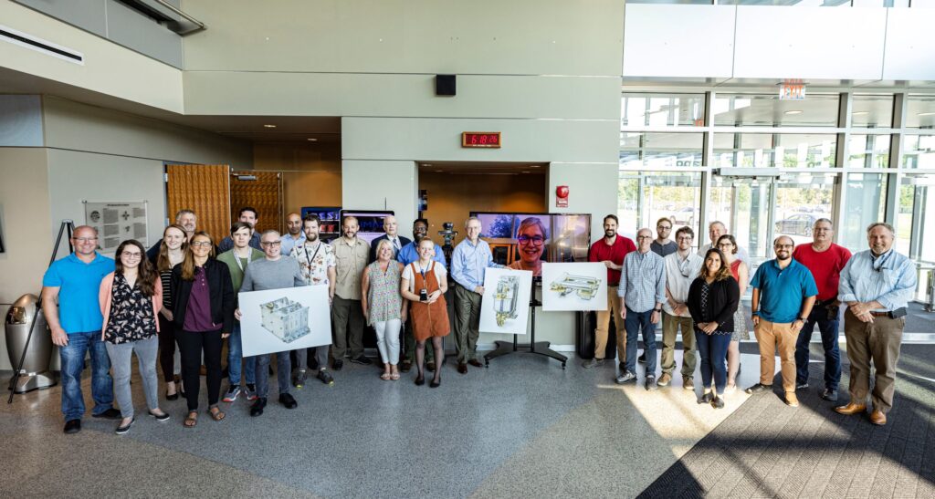 An image of a group people gathered in a building for a photo.