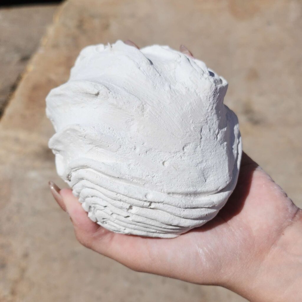 Psyche's Touch is a small plaster asteroid fits in your hand. Raised ripples radiate out like waves in water from the hand print underneath. This sculpture captures a moment of touch echoing outward, like a quiet ripple through space.