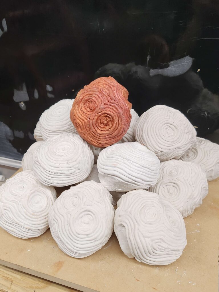 Psyche's Touch is a small plaster asteroid fits in your hand. Raised ripples radiate out like waves in water from the hand print underneath. This sculpture captures a moment of touch echoing outward, like a quiet ripple through space.