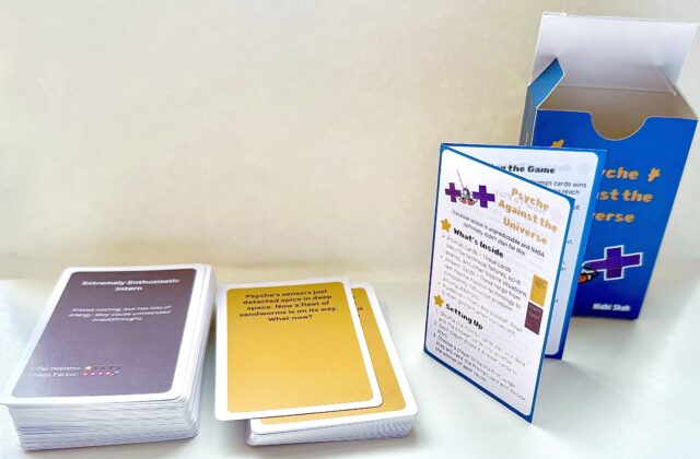The card game consists of a blue box decorated with cartoonish designs including the spacecraft with punching mitts. Inside there are yellow prompt cards and brown answer cards with a title and funny description. Answer cards also have rankings for their effectiveness and chaos factor. There is also a rulebook which describes the contents and additional rules to add chaos to the game.